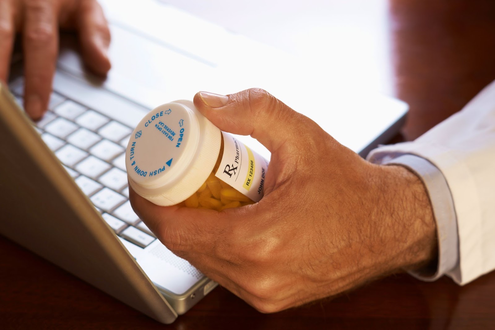 A man holding a bottle with pills