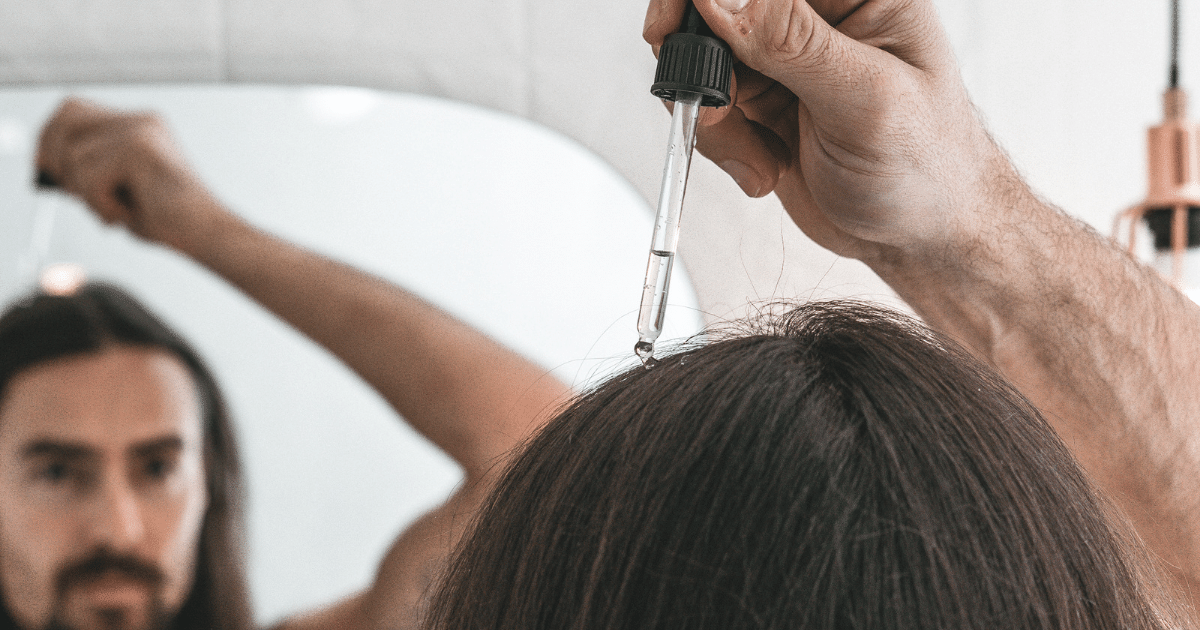 Man applies minoxidil topical to scalp