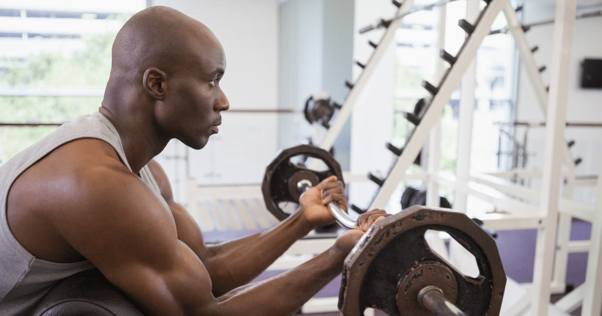 bald man doing exercise by lifting weights